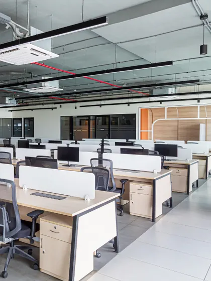 The main workstation area is designed as an open plan to maximize natural light and encourage fluid movement. The exposed ceiling with clean, linear lighting adds an industrial touch while keeping the space feel airy and expansive.