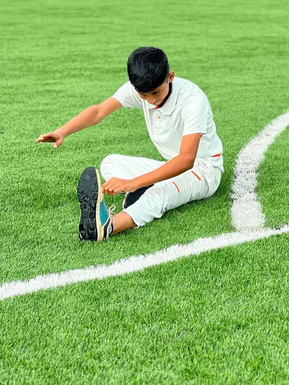 A player focuses on tying his shoelaces while stretching. Every detail matters, from proper gear to a disciplined approach to fitness.