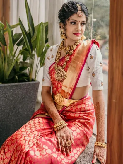 A full-length view of the bride in her red Kanjeevaram and elegant white blouse, a timeless and sophisticated choice.