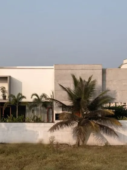 The side elevation of The Quarry House shows a composition of solid white and textured concrete volumes. This play of materials and forms creates a dynamic and visually interesting facade that changes with the light.