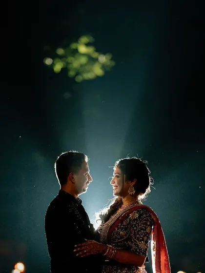 A dramatic silhouette of the couple against a single beam of light, creating a magical and artistic portrait.