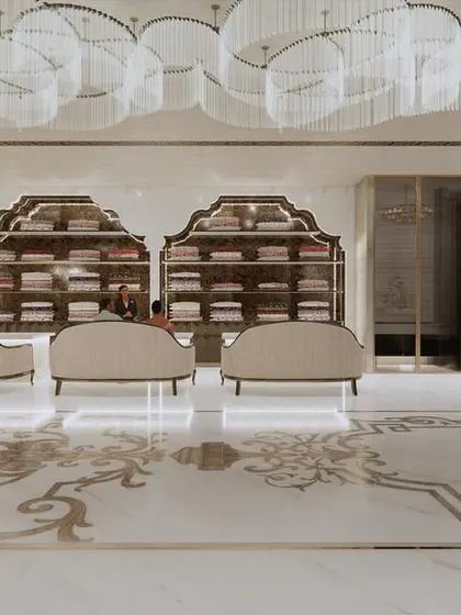 A frontal view of the main showroom floor at Frontier Bazaar. The symmetrical arrangement of seating and display shelves, illuminated by a series of grand chandeliers, creates a sense of balance and regal order.
