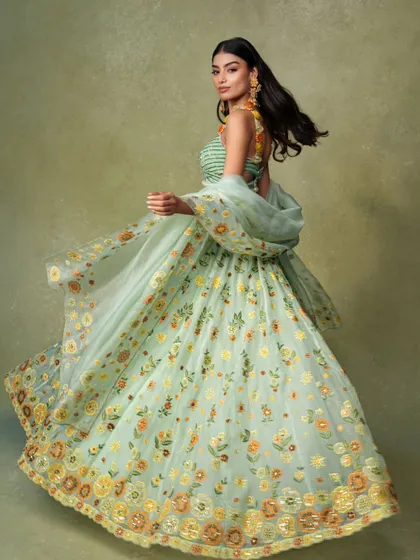 A joyful, twirling shot that brings a light green floral lehenga to life. This type of dynamic image is highly engaging for social media and campaigns.