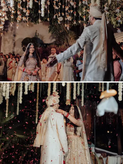 The bride's entry and the moment she places the varmala on the groom, all under a canopy of white flowers.