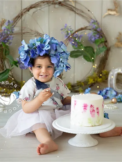 A beautiful floral-themed cake smash, with a stunning flower crown and a delicately painted cake. I love how her happy expression lights up the entire photo.