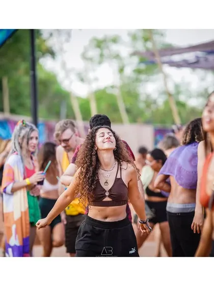 A candid moment of a woman lost in the music at a festival. The soft focus and warm light capture the atmosphere and the feeling of the event.