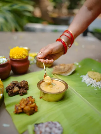 A spoonful of Rasakalan, a unique North Kerala curry, being served on the banana leaf. This dish, a personal favorite of mine, is a delicious blend of flavors that sits somewhere between a rasam and a kalan.