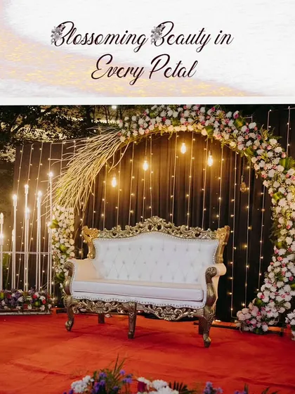 A classic and elegant reception stage featuring a circular floral arch and dramatic candelabras. The ornate white and gold sofa sits on a red carpet, creating a timeless and regal look.