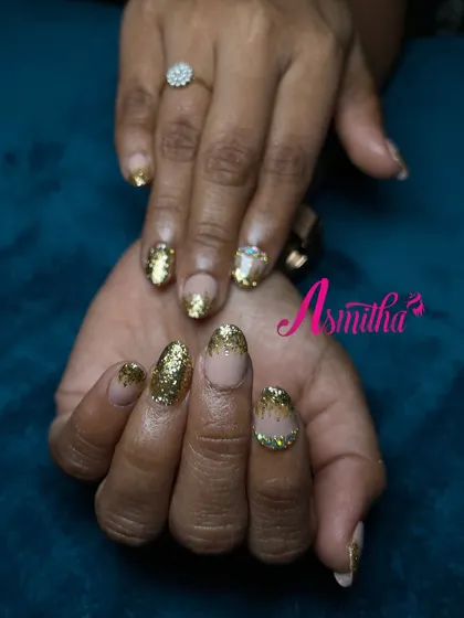 A close-up of the full-coverage gold glitter nails. This is a glamorous and celebratory look, ideal for brides or anyone attending a grand function.