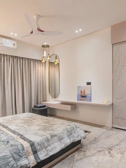 A look at the other side of the room, showing a floating dressing table with a modern oval mirror. The textured wardrobe doors add another layer of subtle detail to the design.
