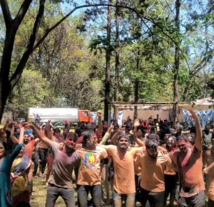 The crowd enjoying the music and colors at the large-scale Holi celebration.