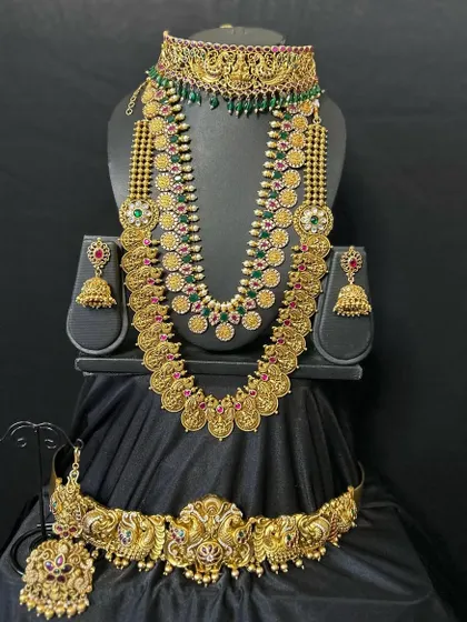 A classic combination of a temple choker and a coin necklace (kasulaperu). This set provides a layered look that is both traditional and stylish for any bride.