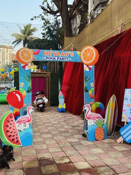 A fruity and fun entrance to Heyaan's Pool Party, with cutouts of watermelons, oranges, and flamingos.