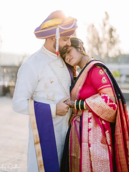 A tender moment as the groom kisses the bride's forehead.