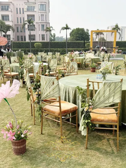 A row of beautifully decorated guest tables and chairs on the lush lawn.