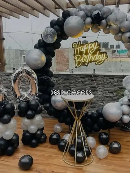 A sleek and modern 40th birthday rooftop decoration with a black and silver balloon ring and matching number balloons.