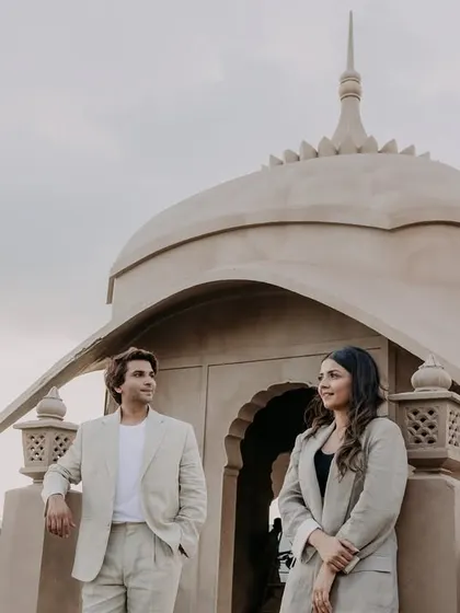 A quiet, posed portrait on a balcony overlooking the Jaipur landscape. The soft light and their calm expressions give this pre-wedding photo a serene and elegant feel.