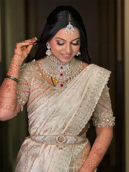A close-up of the bride's serene expression. The delicate embroidery on her blouse and her stunning jewelry complete her breathtaking bridal look.