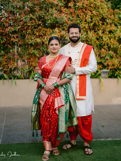 A classic portrait of the bride and groom in their traditional Maharashtrian wedding attire.