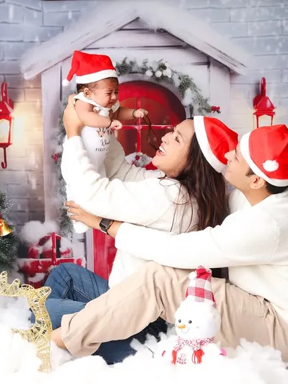 A playful moment during a family Christmas session, with the parents lifting their baby high in the air. These are the candid memories you'll cherish forever.