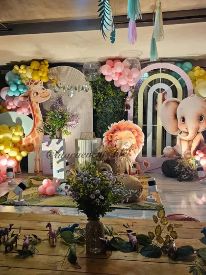 A view from the kids' table at the pastel jungle party, showing how the decor creates an immersive environment with animal figures on the table and the main backdrop in view.