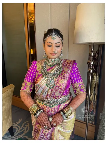 Nidhi's complete bridal look. The heavy silk saree and ornate jewelry are balanced with makeup that is both glamorous and elegant, a signature of my style.