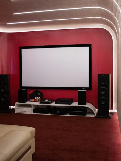 This dedicated home theatre room features a bold red design with custom lighting. It's built to demonstrate how I can tailor the aesthetics of your cinema room to your personal style.