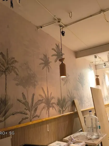 Another angle of the grayscale palm tree mural during installation.