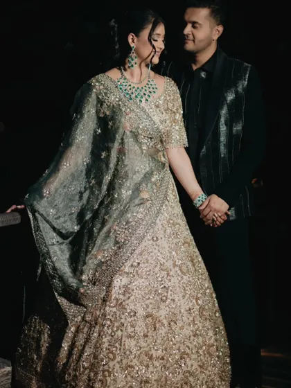 An intimate moment between the couple during their Sangeet. The dramatic lighting creates a romantic and timeless feel.