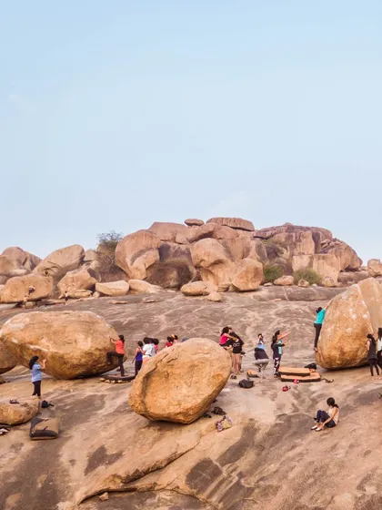 A wide-angle shot of a group climbing in Hampi. This shows the scale of the boulder fields and the community atmosphere of our outdoor sessions.