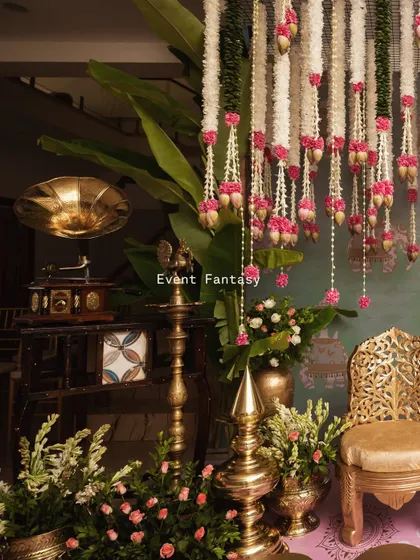 For this pre-wedding ritual, I blended vintage and traditional elements. A classic gramophone sits beside brass lamps and hanging floral garlands, creating a unique and nostalgic atmosphere.