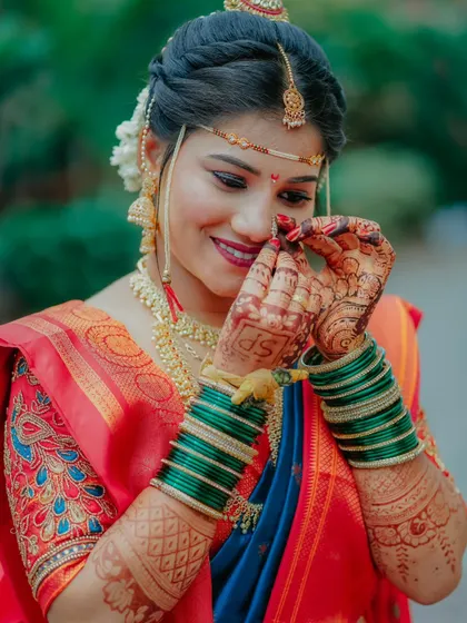 A close up of the bride's hands, adorned with green bangles and intricate mehndi, as she adjusts her nose ring. It's these small, delicate moments that I love to capture.