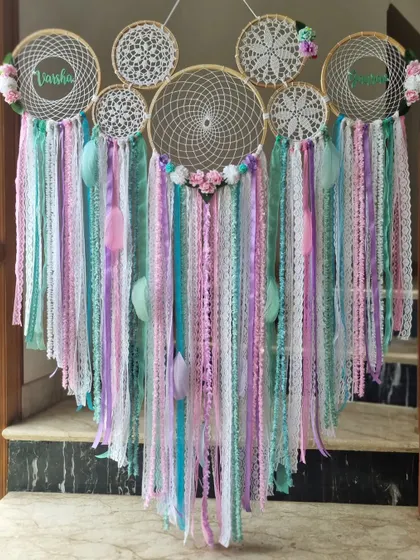 A pastel floral dreamcatcher that feels like a soft whisper of serenity. Personalized with the names 'Varsha' and 'Isha', it's a beautiful piece to celebrate a special bond.