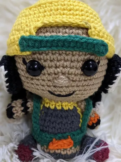 A close-up of the Raze doll from Valorant, with her yellow cap and detailed outfit.