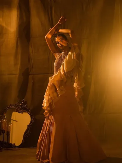 A full-length shot for Nayantaara, showcasing a glamorous ruffled saree. The makeup is polished and elegant, designed to complement the dramatic silhouette of the outfit.