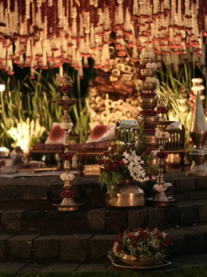The mandap steps lit by traditional brass lamps and adorned with floral arrangements, adding to the sacred and serene atmosphere of the ceremony.