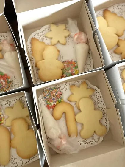 A peek inside my Christmas cookie decorating kits, all boxed up and ready for a party. Each box contains plain cookies in festive shapes, bags of colorful icing, and of course, plenty of sprinkles.