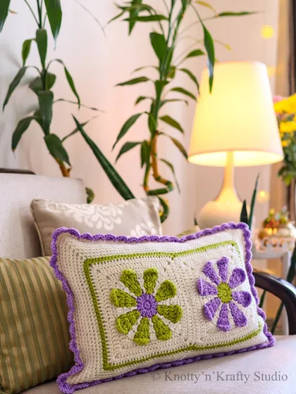 As the temperatures drop, cozy woven cushions and pops of colour are a must. This floral cushion in green and purple adds a cheerful touch to a neutral sofa.