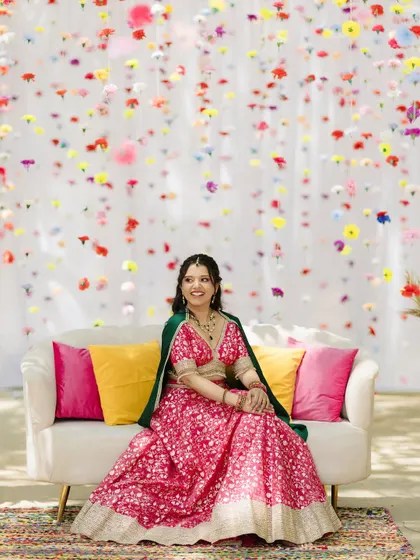 The bride enjoying her moment in front of the suspended flower backdrop. The colorful blooms create a beautiful, floating curtain of flowers.