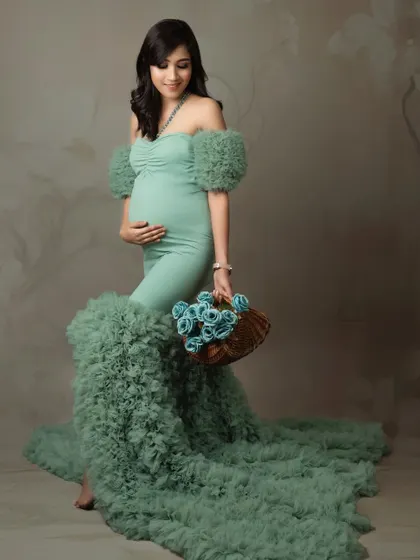 A classic solo maternity pose. Holding a basket of flowers adds a lovely, natural element to this studio portrait.