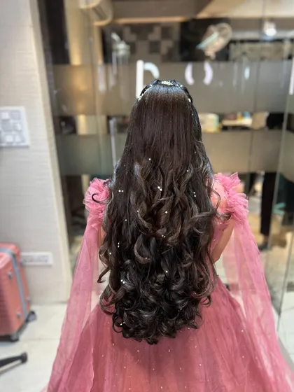 Another angle of the long, curly hairstyle, showing the beautiful drape of the hair.