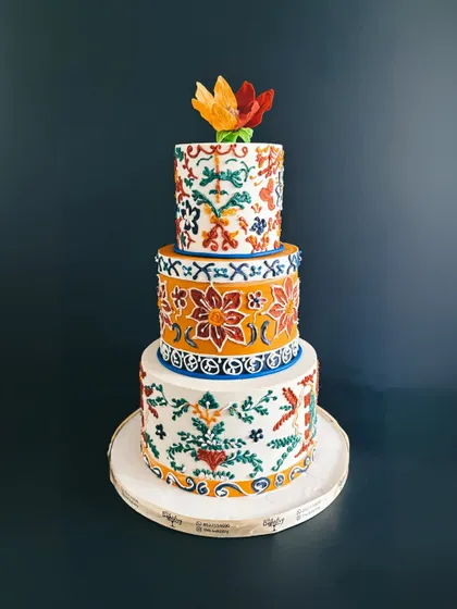 A full, stunning shot of the three-tiered Rangoli cake, a true work of edible art.