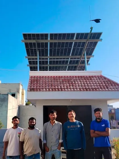 A proud homeowner with our team in front of his house, which now features a rooftop solar installation.