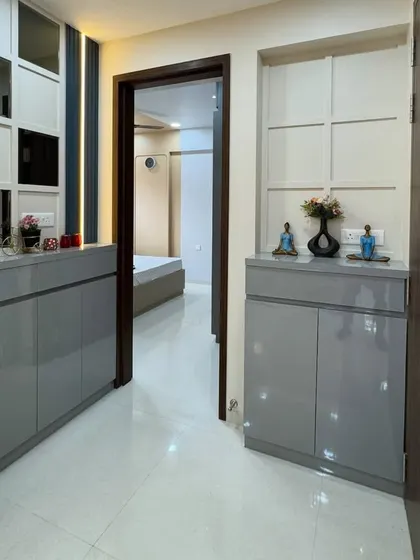 A sleek and functional entryway console in a glossy grey finish. The design includes cabinets for shoe storage and a mirrored panel above to make the hallway feel brighter and more spacious.