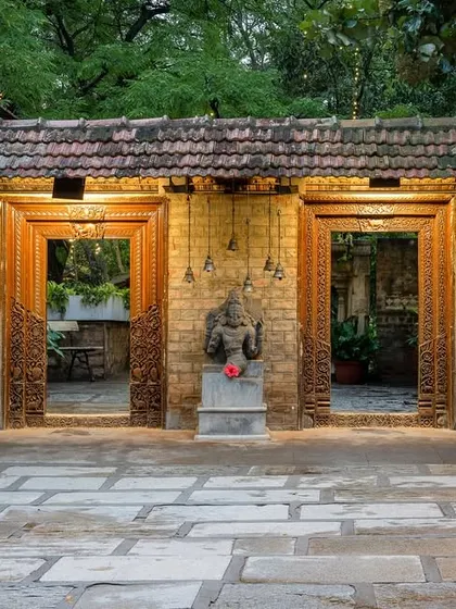 The entrance to one of our courtyards, with its antique carved doors and stone deity, sets a tone of reverence and heritage from the moment you step through.