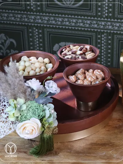 My wooden dry fruit platter, complete with a floral accent, is a beautiful and useful gift. The combination of rich wood, a brass-finished base, and premium nuts makes it a standout piece.