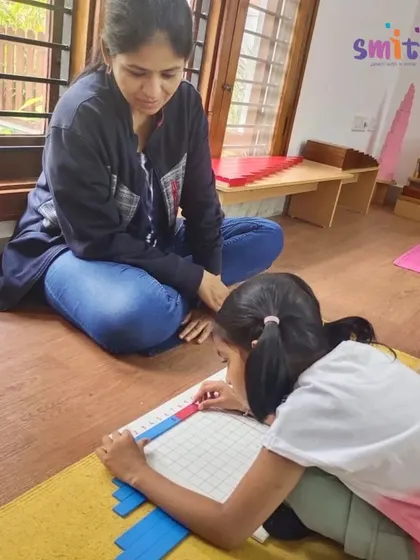 A parent observes her daughter working with math materials. Our observation sessions provide a wonderful window for parents to see their child's progress and independence in the classroom.