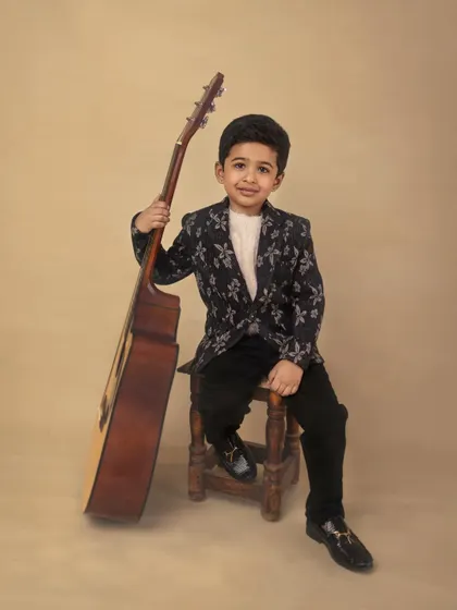 A young musician in the making. This portrait of a boy with his guitar has a cool, relaxed vibe, capturing a personal interest in a stylish way.