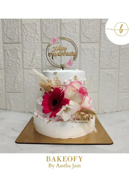 The client wanted an elegant and classy cake for her parents' anniversary with florals, gold, and pearls. I created this two-tier vanilla cake, and her happy reaction was everything.