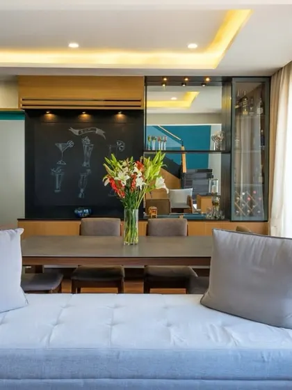 A pop of color from fresh yellow flowers brings warmth and personality to this cozy bedroom, where a mix of textures and tones creates a welcoming and stylish atmosphere.